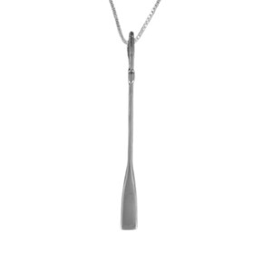 May include: A silver-toned pendant shaped like a long, slender boat paddle, suspended from a delicate matching silver-toned chain. The pendant features a smooth, elongated shaft and a flat, tapered blade at the bottom, reflecting a metallic sheen.