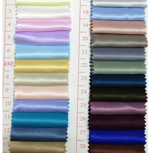 May include: A color swatch card featuring 30 satin fabric samples in a variety of colors. The swatches range from light pastels to deep jewel tones, including shades of pink, blue, green, and brown. Each swatch is numbered for easy reference.