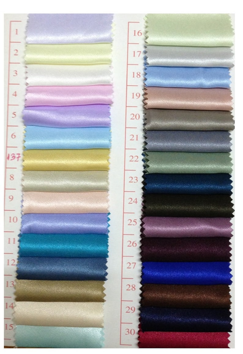 May include: A color swatch card featuring 30 satin fabric samples in a variety of colors. The swatches range from light pastels to deep jewel tones, including shades of pink, blue, green, and brown. Each swatch is numbered for easy reference.