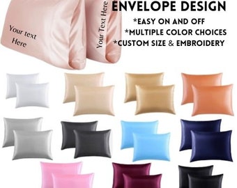 May include: A selection of satin pillowcases in various colours, including white, silver, black, blue, pink, and burgundy. The image also shows a light pink pillowcase with the text "Your text Here" and "Your Text Here". Text on the image reads "ENVELOPE DESIGN".