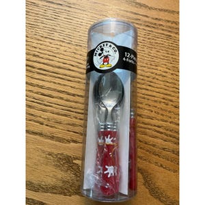 May include: A 12-piece Mickey & Co. flatware set in a clear cylindrical plastic container. The set includes forks and spoons with red handles featuring white glove graphics. The black label displays the Mickey & Co. logo and text 12-Piece.