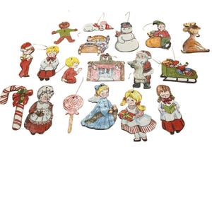 Puede incluir: Una colección de adornos navideños vintage. Los adornos incluyen un muñeco de nieve, Papá Noel, ángeles, un hombre de jengibre, una cama, una chimenea, un bastón de caramelo y un reno. Cada adorno está pintado con colores brillantes y tiene un pequeño gancho de metal.