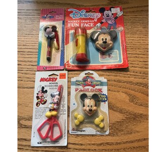May include: Four packaged Disney Mickey Mouse items including a pen necklace, a light-up flashlight toy, 4.5 inch school scissors with a character handle, and a padlock with two keys. Each item is sealed on its original branded cardboard backing.
