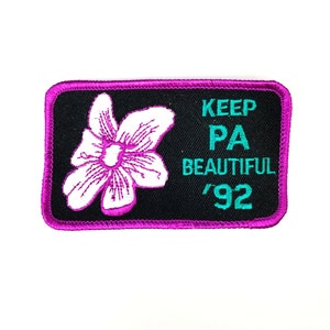 May include: A black and pink embroidered patch with a white flower and the text "KEEP PA BEAUTIFUL '92".