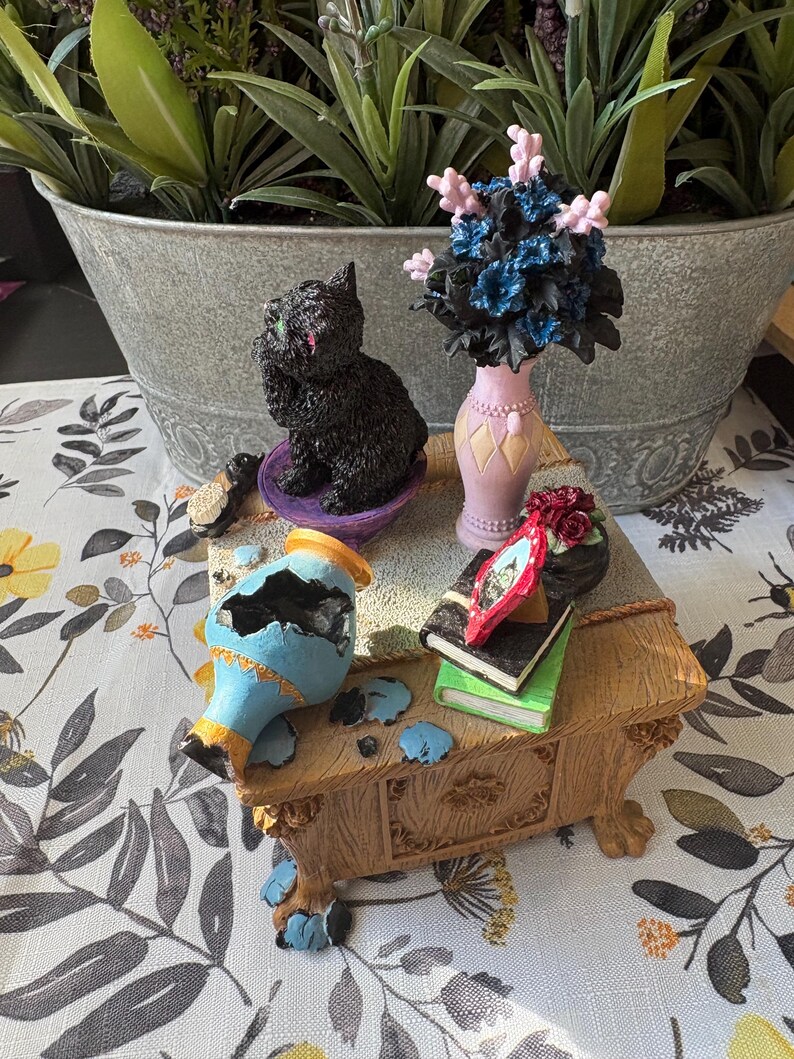 May include: A white ceramic mug with a black handle and the text "But First, Coffee" in a black, bold font. The mug is on a white surface. The mug is approximately 4 inches tall.