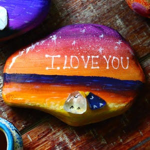 Pájaros de vidrio marino sobre piedra de playa al atardecer – Piedra pintada a mano con la frase «TE AMO» | Regalo para alguien especial