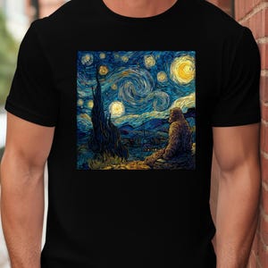 May include: Black t-shirt with a colourful, artistic image of a Sasquatch figure observing a starry night sky, in the style of Van Gogh. The design uses swirling blues, yellows, and greens, creating a unique and striking visual.