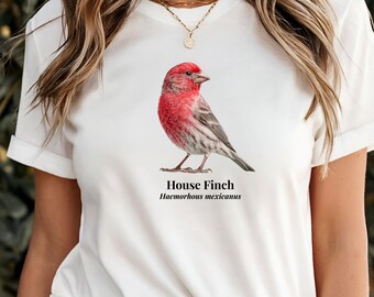 May include: A white short-sleeved t-shirt featuring a detailed illustration of a House Finch with a vibrant red head and breast. Below the bird, the text reads House Finch and Haemorhous mexicanus in a clean, black, serif font centred on the chest.