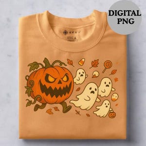 Puede incluir: Sudadera naranja con un diseño de Halloween. El gráfico muestra una calabaza con una expresión enfadada, fantasmas, caramelos y hojas de otoño. La sudadera está doblada.