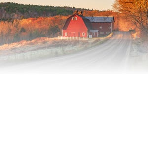 May include: A scenic landscape featuring a red barn with a white fence and a long, winding road. The barn is set against a backdrop of colorful autumn trees and a clear sky. The road leads towards the barn, creating a sense of depth.
