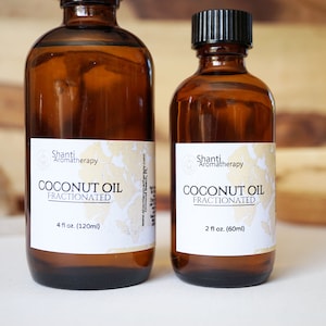 May include: Two amber glass bottles of fractionated coconut oil. The larger bottle is labeled 4 fl oz (120ml), and the smaller is 2 fl oz (60ml). Both have black caps and white labels with the text "Shanti Aromatherapy COCONUT OIL FRACTIONATED."