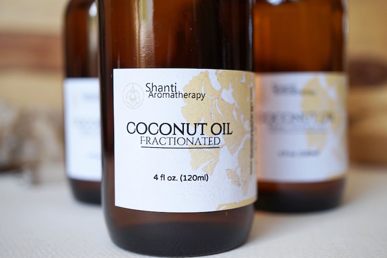 May include: Three brown glass bottles of fractionated coconut oil. Each bottle has a white label with the text "Shanti Aromatherapy" and "Coconut Oil Fractionated". The label also indicates the bottle contains 4 fl oz (120ml).