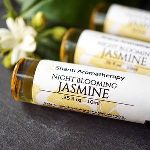 May include: Three small glass bottles with white labels and gold caps. The labels have the text "Shanti Aromatherapy" and "Night Blooming Jasmine" with the measurement ".35 fl oz 10ml".