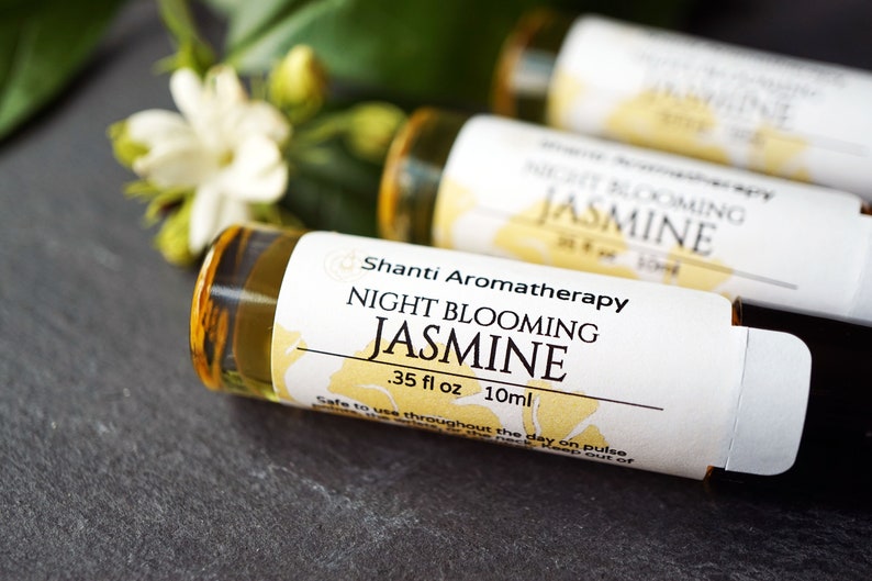 May include: Three small glass bottles with white labels and gold caps. The labels have the text "Shanti Aromatherapy" and "Night Blooming Jasmine" with the measurement ".35 fl oz 10ml".