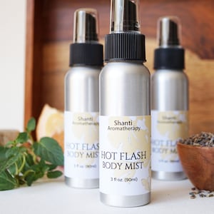 May include: Three silver spray bottles with white labels that read "Shanti Aromatherapy Hot Flash Body Mist" and "3 fl oz. (90ml)".