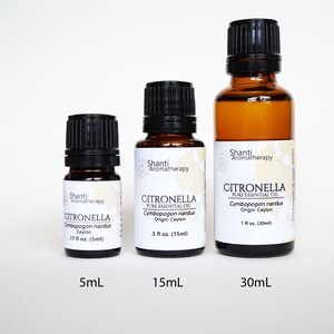 May include: Three amber glass bottles of citronella essential oil in sizes 5ml, 15ml, and 30ml. The bottles have black caps and white labels with the brand name "Shanti Aromatherapy" and the product name "Citronella Pure Essential Oil".