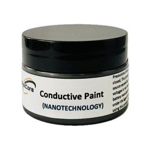 May include: A small jar of conductive paint with a black lid and a white label. The label reads "Conductive Paint (NANOTECHNOLOGY)". The jar is cylindrical and sits on a white surface.