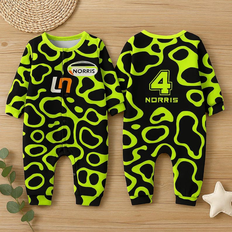 May include: A baby's jumpsuit with a black and neon green pattern. The front features the text "NORRIS" and the number "47". The back of the jumpsuit has the number "4" and the name "NORRIS". The jumpsuit has long sleeves and a round neckline.