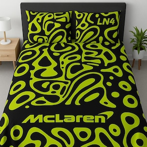 May include: Black and neon green bed linen set with an abstract design. The McLaren logo is visible, along with the text "LN4" on the pillowcases. The bedding is on a black bed frame.