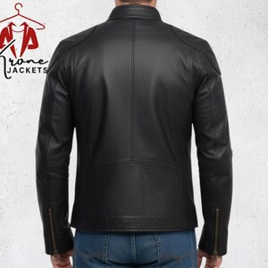 K&ouml;nnte beinhalten: Schwarze Lederjacke mit Stehkragen und Rei&szlig;verschlussdetails an den &Auml;rmeln. Die Jacke hat ein gestepptes Design an Schultern und unterem R&uuml;cken. Das Logo "Krone Jackets" ist oben links sichtbar.
