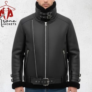 May include: Black leather jacket with a high collar, a zip fastening, and a belt. The jacket features a shearling lining and the text "Krone Jackets" in the upper left corner.
