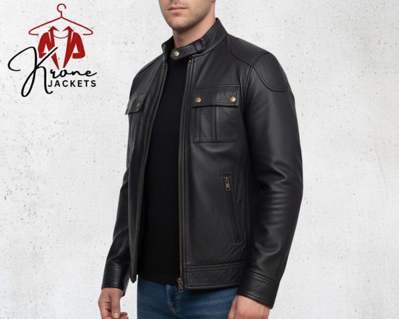 K&ouml;nnte beinhalten: Schwarze Lederjacke mit Stehkragen, zwei Brusttaschen und Rei&szlig;verschluss. Die Jacke wird &uuml;ber einem schwarzen Shirt und blauen Jeans getragen. Das Logo "Krone Jackets" ist sichtbar. Klassisches und zeitloses Design.