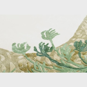 May include: Close-up of a textile with an embroidered design featuring green and blue-green plant-like forms against a beige and off-white background. The design has a textured, three-dimensional appearance, suggesting a rug or wall hanging.