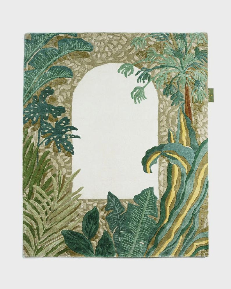 May include: A rectangular rug featuring a botanical design with an archway. The rug showcases lush green and yellow foliage, including palm trees and large leaves, framing a central white space. The border has a textured, stone-like appearance.