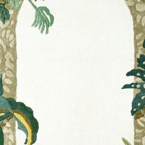 May include: A decorative rug with a white arched center, framed by a textured, light brown border. Green and yellow-green leaves and foliage are arranged around the arch, creating a natural, botanical theme.