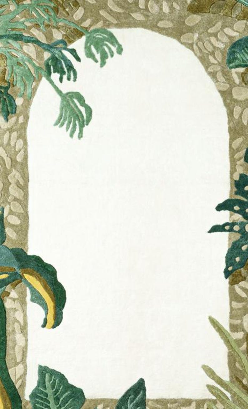 May include: A decorative rug with a white arched center, framed by a textured, light brown border. Green and yellow-green leaves and foliage are arranged around the arch, creating a natural, botanical theme.