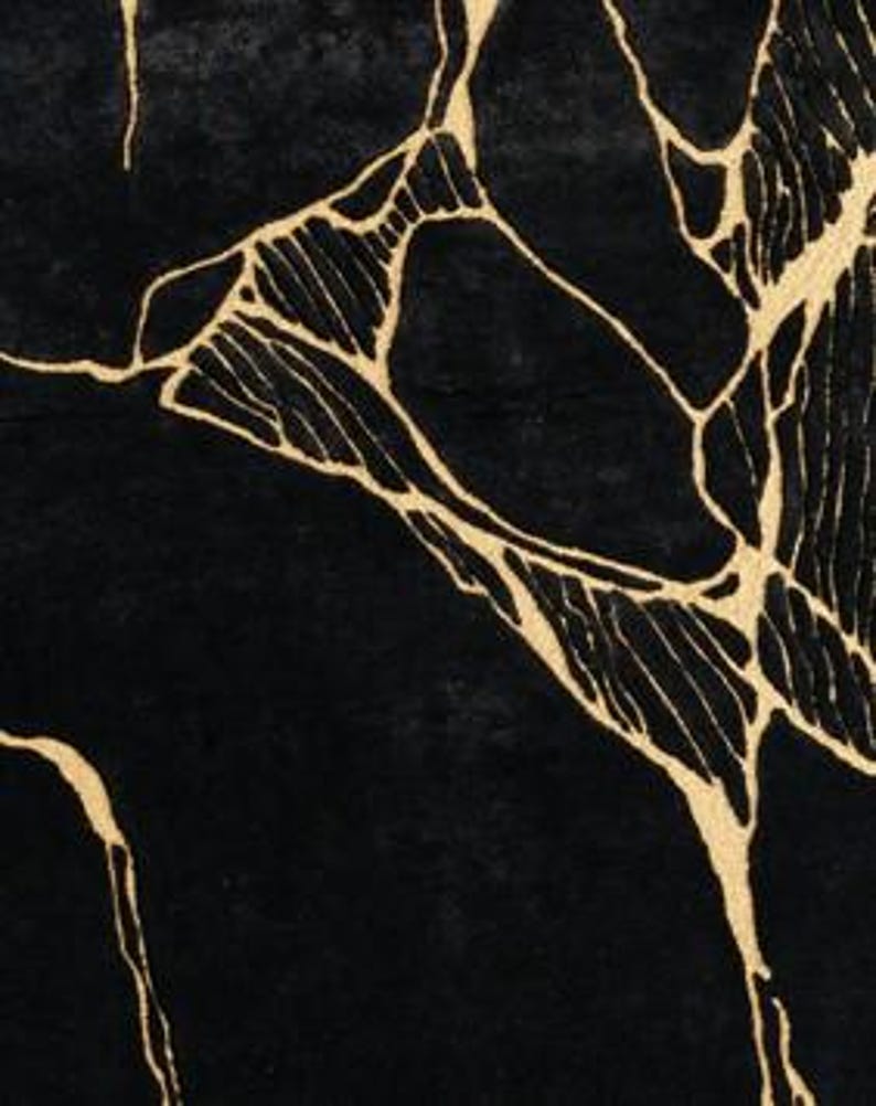 May include: Black rug with a gold, abstract, vein-like pattern. The design features irregular, interconnected lines in a metallic gold color against a solid black background. The rug's texture appears soft and plush.