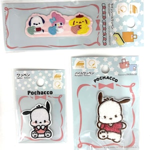 Puede incluir: Tres parches bordados de personajes de Sanrio en envases transparentes. Una tira larga presenta a Pochacco, My Melody y Pompompurin. Dos paquetes individuales contienen parches de Pochacco, uno sentado y otro de pie.