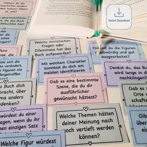 Könnte beinhalten: Eine Sammlung pastellfarbener Karten mit deutschem Text, angeordnet um ein offenes Buch mit Lesezeichen und Stift. Die Karten enthalten Fragen zur Literatur, ideal für Buchclub-Diskussionen oder persönliche Reflexionen.