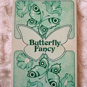 Juego de cajas antiguas con hojas de papelería con diseño de mariposas y sobres con diseño de mariposas