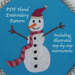 May include: A hand-embroidered snowman design on a blue background. The snowman wears a red hat and scarf, with a carrot nose and stick arms. The text "PDF Hand Embroidery Pattern" and "Including illustrated step-by-step instructions" are visible.