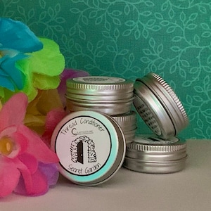 May include: A stack of five silver metal tins with a label on the bottom tin that reads "Thread Conditioner Secret Garden".