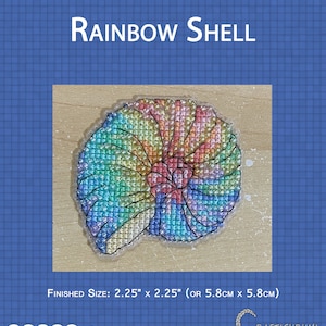 May include: A rainbow colored shell cross stitch pattern on a wooden background. The finished size is 2.25 inches by 2.25 inches or 5.8 centimeters by 5.8 centimeters. The pattern is labeled as intermediate difficulty.
