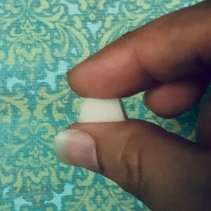 May include: A close-up of a white, round, ceramic button.