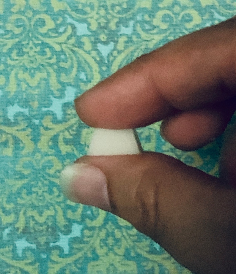 May include: A close-up of a white, round, ceramic button.