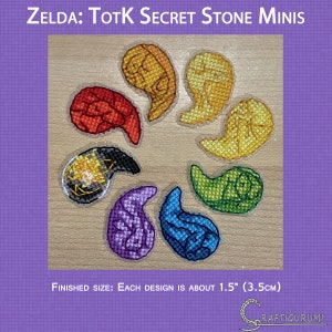 Op de afbeelding: Acht kleurrijke viltstenen ontwerpen uit de videogame The Legend of Zelda: Tears of the Kingdom. Elk ontwerp is ongeveer 3,8 cm in diameter en heeft een andere steen uit het spel. De stenen zijn in een cirkel op een houten oppervlak gerangschikt.