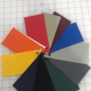 May include: A color chart of fabric swatches in various colors, including orange, red, beige, maroon, blue, gray, dark gray, navy blue, black, and green.