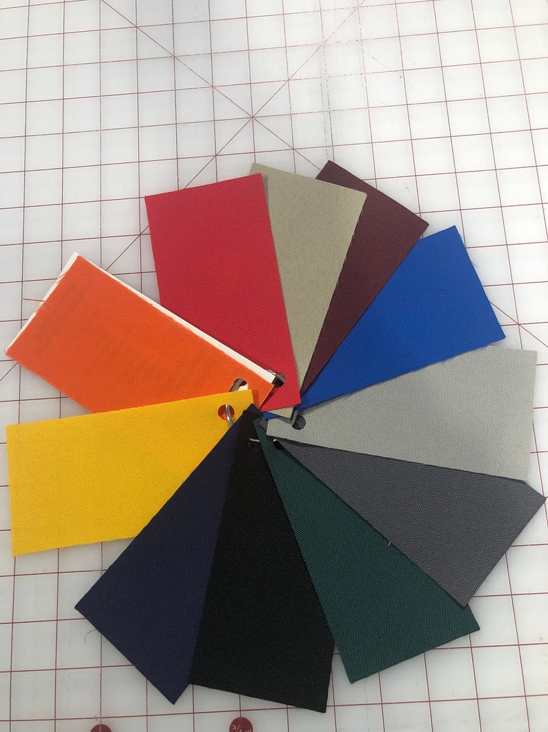May include: A color chart of fabric swatches in various colors, including orange, red, beige, maroon, blue, gray, dark gray, navy blue, black, and green.