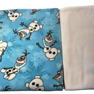 May include: A blue fleece blanket with a white fleece backing. The blue side features a repeating pattern of Olaf the Snowman from the movie Frozen.
