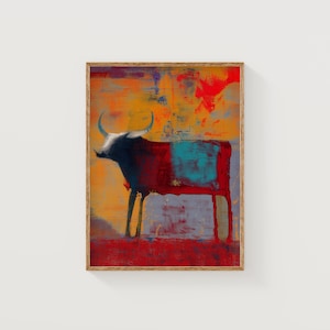 May include: Abstract bull art print in a wooden frame. The bull is mainly red and black, with a turquoise square on its side. The background features orange, yellow, and purple hues.