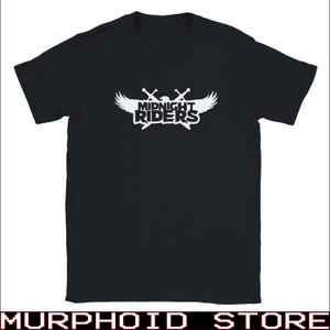 May include: A black short-sleeved t-shirt featuring a white graphic on the chest. The design displays the text "MIDNIGHT RIDERS" in a bold font, positioned over a pair of crossed swords and a pair of stylised wings extending from the sides.