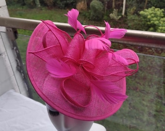 Tocado de sinamay rosa fucsia: un accesorio llamativo y vibrante.