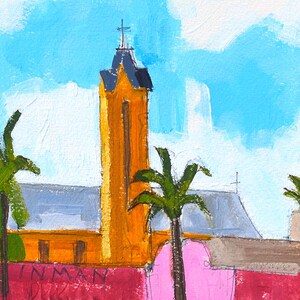 May include: A painting of a yellow church with a tall steeple and a cross on top. There are palm trees in the foreground and a pink wall with the word "INMAN" written on it.