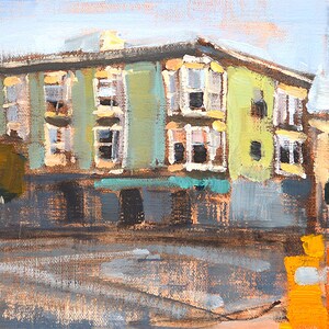 May include: An original oil painting of a building with a green and yellow facade. The artwork depicts a street scene with a building, a tree, and a utility pole. The painting has a textured appearance and is signed in the lower left corner.