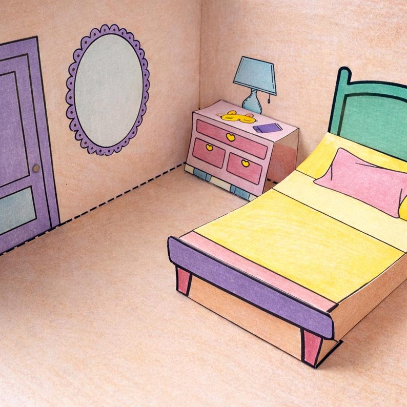 May include: A papercraft bedroom scene featuring a bed with a yellow blanket and pink pillow, a nightstand, a lamp, and a mirror. The room is colored in pastel shades of pink, purple, and green, with black outlines defining the furniture and room details.