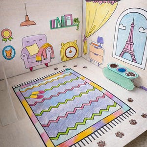 May include: A colorful, hand-drawn diorama of a room, featuring a purple armchair, a zigzag patterned rug, and a window with the Eiffel Tower. A cat bowl and paw prints are also visible, suggesting a pet-friendly theme.
